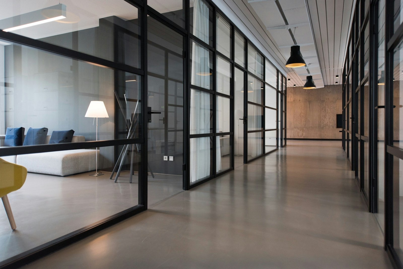 An office corridor lined with glass-walled rooms
