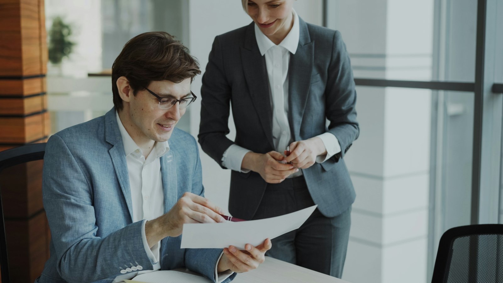 A senior lawyer handing a document to a colleague